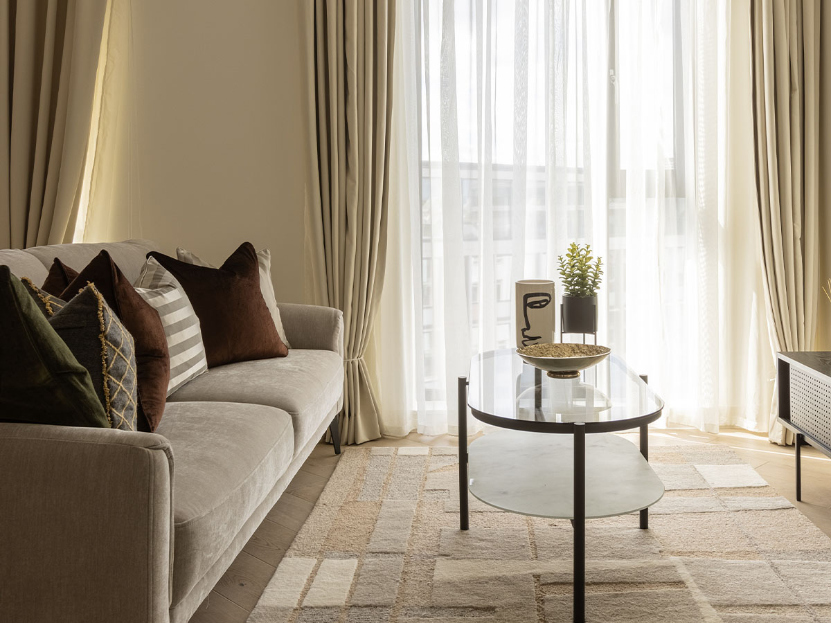 Bright-living-room-with-beige-sofa-glass-coffee-table-and-natural-light-of-Pembridge-Gardens-Notting-Hill