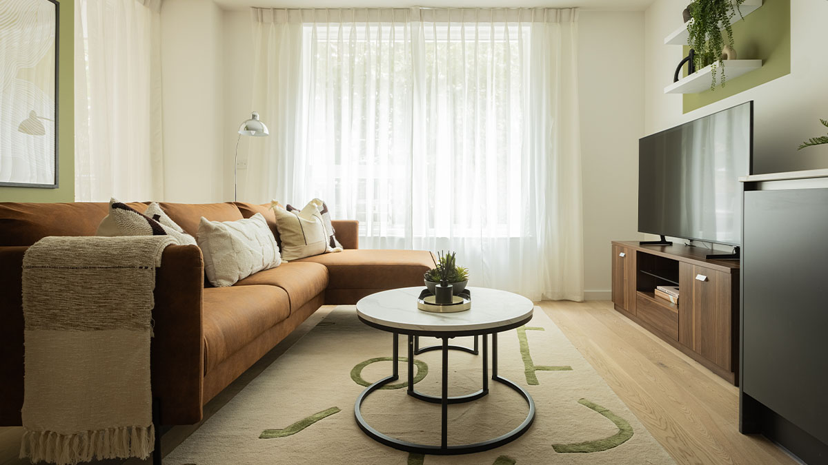 living-room-with-a-brown-leather-sectional-sofa-coffee-table-and-TV-of-Verdica-show-flats